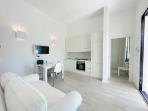 ein weißes Wohnzimmer mit einem weißen Sofa und einem Tisch in der Unterkunft Villetta La Rocca in Pietrasanta