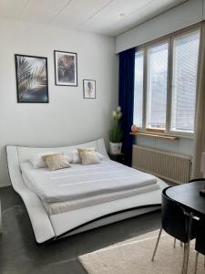 a bedroom with a large white bed and a table at Kotapiha in Liperi