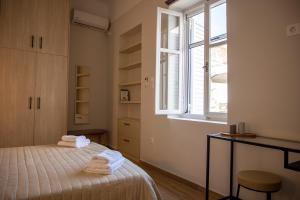 a bedroom with a bed with towels on it at Happiness Aegina Apartments in Aegina Town