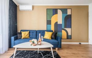 sala de estar con sofá azul y mesa en APARTMENT 24H WITH FREE GARAGE AND AC Jagiełły 5, en Wroclaw