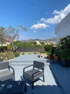 a patio with two chairs and a table at Happiness Aegina Apartments in Aegina Town