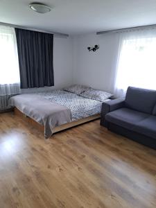 1 dormitorio con 1 cama y 1 sofá en U OLIWII, en Krościenko nad Dunajcem
