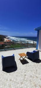 a patio with two chairs and a table and the beach at Mega Ocean Magoito - Guest House - Sintra in Sintra