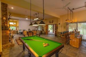 a living room with a pool table in it at StayVista at Peacocks & Partridges with Amidst Greenery, Terrace, Indoor Fireplace, Bar & Snooker Table in Hoshiārpur
