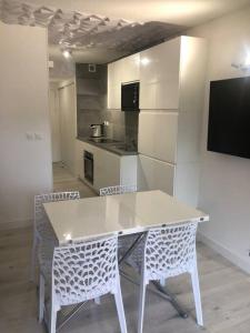 a kitchen with a table and chairs in a room at Studio 25m2 hyeres plages in Hyères +4 photos