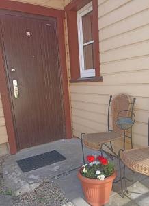 a porch with two chairs and a door with a pot of flowers at Vingi Apartment 12 in Pärnu