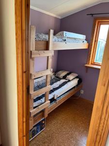 a bedroom with two bunk beds and a window at Stuga med havsutsikt i Falkenberg in Falkenberg