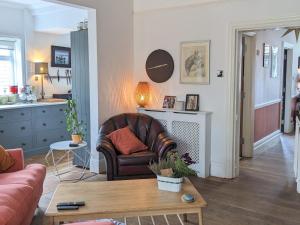 a living room with a leather chair and a table at Pass the Keys Spacious Characterful Home in Bournemouth