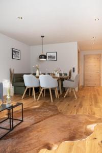 a living room with a wooden floor and a table and chairs at Going Living in Going am Wilden Kaiser