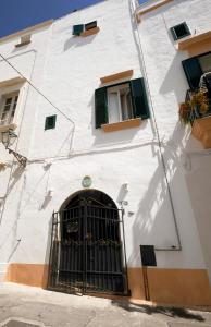 a white building with a door and a window at Palazzo Rocci Rooms in Gallipoli