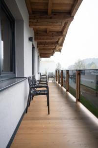 a row of benches sitting on the balcony of a building at Going Living in Going am Wilden Kaiser