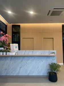 a reception counter in a lobby with flowers at บ้านสุขใจ สามใบเถา 