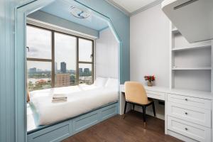 Cette chambre comprend un lit, un bureau et une fenêtre. dans l'établissement Saigon Royal Apartment with Panorama City View, à Hô-Chi-Minh-Ville