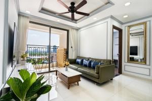 - un salon avec un canapé et un ventilateur de plafond dans l'établissement Saigon Royal Apartment with Panorama City View, à Hô-Chi-Minh-Ville