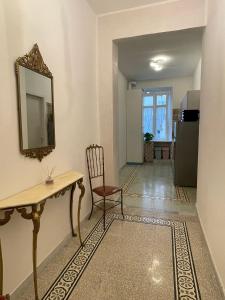 a room with a table and a chair and a refrigerator at La casa in centro in Salerno