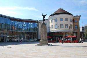 a statue in a plaza in front of a building at Cloud9StayZ at The Leafield in Woking