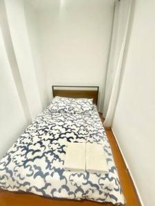 a small bed in a small room with a bedsheet at Atocha ferrocarril 4 in Madrid