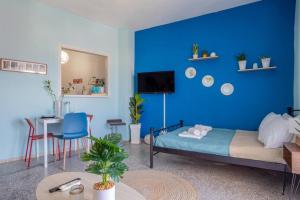 um quarto com uma parede azul com uma cama e uma mesa em Blue Suite Manos, in Heraklion em Heraclião