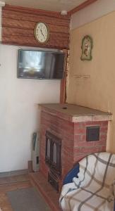 a room with a fireplace and a clock on the wall at Vingi Apartment 12 in Pärnu