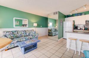 uma sala de estar com um sofá e uma cozinha em 0701 The Green Starfish by Atlantic Towers em Carolina Beach