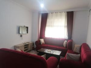 - un salon avec un canapé rouge et une fenêtre dans l'établissement Furnished apartment in Jubeiha, à Amman