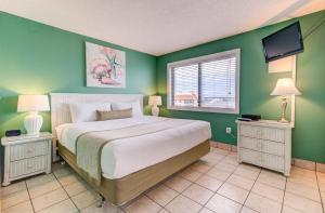 1 dormitorio con 1 cama grande y paredes verdes en 0701 The Green Starfish by Atlantic Towers, en Carolina Beach