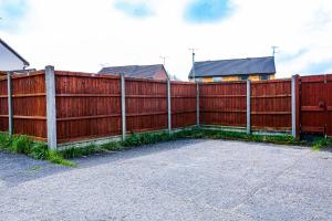 a red fence next to a sidewalk next to a building at Pass the Keys Cosy Home in Chelmsford in Chelmsford