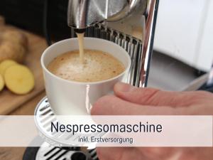 una persona está sosteniendo una taza de café en HaFe Ferienwohnung Bad Sachsa - waldnah, hundefreundlich, Smart Home Ausstattung en Bad Sachsa