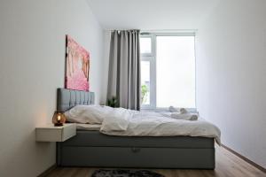 a bedroom with a bed with a window at Klassen Apartments! Erleben Sie Aulendorf in dieser modernen Unterkunft in Aulendorf