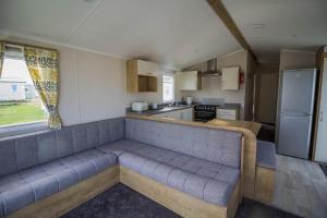 a living room with a couch in a kitchen at 8 Berth Caravan With Decking To Hire At Naze Marine In Essex Ref 17280c in Walton-on-the-Naze