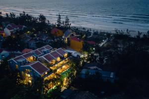 an aerial view of a house with lights on the beach at CHiEM HoiAn - The Beachside Boutique Hotel & Villa in Hoi An