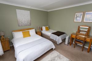 A bed or beds in a room at Fourwinds B&B