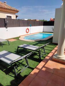 un patio con 2 mesas de picnic y una piscina en Ereza Villa Paraiso en La Oliva