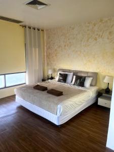 a bedroom with a large white bed with two lamps at Centerpoint Hotel & Plaza in Thongsala