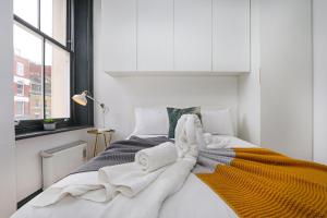 a bedroom with a bed with towels on it at Just-renovated flat in the centre of Shoreditch! in London