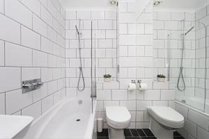 a white bathroom with a toilet and a tub and a sink at Just-renovated flat in the centre of Shoreditch! in London
