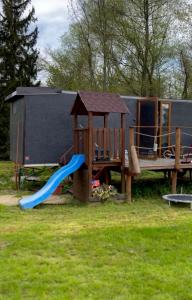 um parque infantil com um escorrega e uma estrutura de jogos em V dedine a predsa mimo nej v maringotke na samote em Dechtice