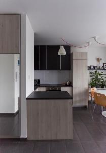a kitchen with black and white cabinets and a table at Dobó Apartman in Szeged