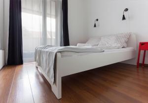 a white bed in a room with a window at Dobó Apartman in Szeged +9 photos