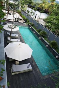una vista aérea de una piscina con sombrillas y sillas en Lovinalife Room & Cafe en Lovina