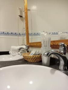 a bathroom counter with a sink and a mirror at Hotel Nuevo Arlanza in Covarrubias