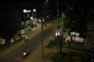 a city street at night with a car on the road at HOLIDAY INN in Konārka