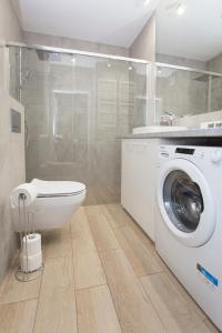 a bathroom with a washing machine and a shower at Apartament obok dworca PKP PKS in Białystok