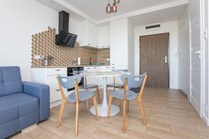 a kitchen and dining room with a table and chairs at Apartament obok dworca PKP PKS in Białystok