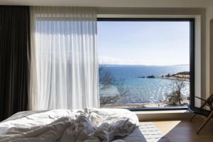 a bedroom with a large window with a view of the ocean at briig boutique hotel in Split