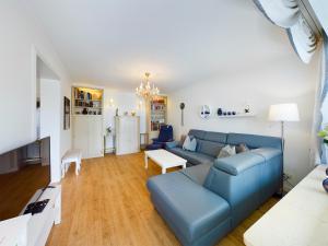 sala de estar con sofá azul y mesa en FeWo Wankblick, en Garmisch-Partenkirchen