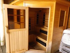 a wooden sauna with a wooden door in a house at Chalet les Alpes - Le Sapey in Vénosc