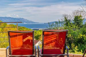 twee stoelen op een veranda met uitzicht op de oceaan bij Apartments Marija in Bribir