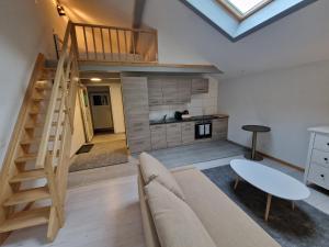 ein Wohnzimmer mit einem Sofa und einer Treppe in der Unterkunft Saaner Valley Home in Boltigen