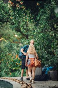 um homem e uma mulher a andar por um jardim em Trang An Ecolodge em Ninh Binh